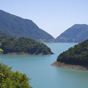Large, calm lake surrounded by forested mountains