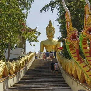 Large golden Buddha statue at the end of a staircase Large golden Buddha statue at the end of a staircase