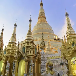 Large golden stupas under a blue sky in an evening mood