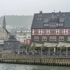 Large half-timbered house with adjacent river and historic city scenery