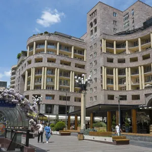 Large, modern building on a busy pedestrianised street with flowers