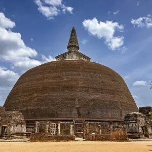 Large stupa under a cloudy sky with surrounding ancient walls Large stupa under a cloudy sky with surrounding ancient walls