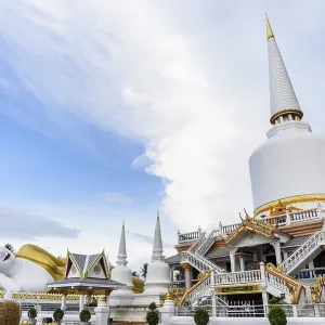 Large white pagoda and Buddha statue under the blue sky in the evening at Wat That Noi