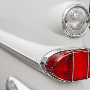 Left tail light with reversing light on a white vintage car with chrome trim Left tail light with reversing light on a white vintage car with chrome trim