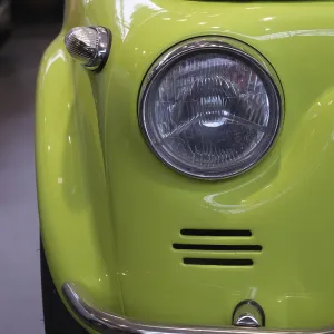 Detail of a light green vintage car with distinctive headlights