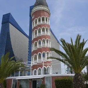 A lighthouse in front of a modern skyscraper