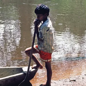 Little boy standing next to a boat Little boy standing next to a boat