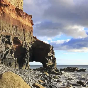 Lonely beach with a natural stone arch on the Atlantic Ocean in the Canary Islands Lonely beach with a natural stone arch on the Atlantic Ocean in the Canary Islands