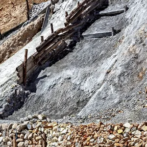 A lonely mine car stands on a rocky slope
