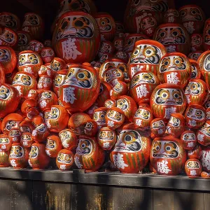 Lots of red Daruma dolls stacked in various sizes on a shelf in a Japanese temple