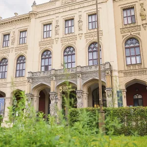 A magnificent historic building with ornate facades surrounded by lush green plants