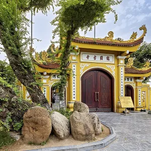 Magnificent Tor tor with golden decorations and trees leading into a Buddhist temple complex Magnificent Tor tor with golden decorations and trees leading into a Buddhist temple complex
