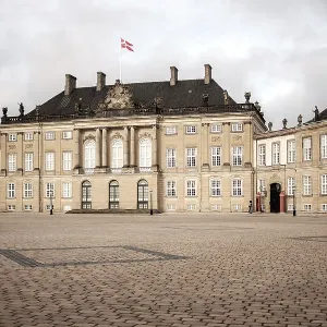 A majestic historic building with a Danish flag