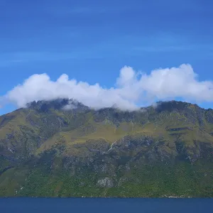 Majestic mountains with clouds against a clear blue sky