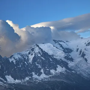 Majestic snow-capped mountains under dramatic cloud formations