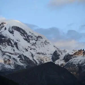 Majestic snow-covered mountain under cloudy sky