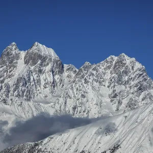 Montagnes majestueuses couvertes de neige dominent un ciel bleu limpide