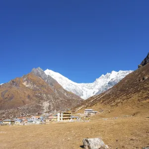 Majestic view of snow-capped Langtang Lirung Himalayan mountain range with Kyanjin Gompa village in foreground in Nepal