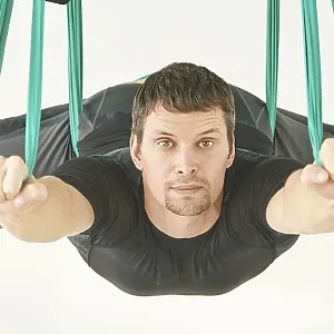 Male person do hammock yoga class exercise Male person do hammock yoga class exercise