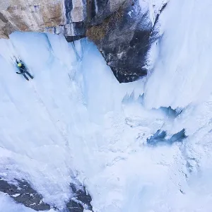 Man is leading on Ice. Ice Climbing on Frozen Waterfall Man is leading on Ice. Ice Climbing on Frozen Waterfall