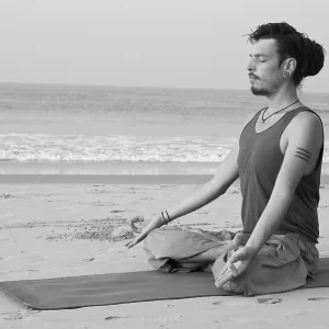 Man meditating on the beach, India Man meditating on the beach, India