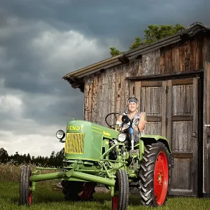 Man with a prosthetic leg driving a vintage tractor
