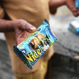 Man showing oil soaked biscuit packets due to container ship chitra colliding in sea Bombay Mumbai Man showing oil soaked biscuit packets due to container ship chitra colliding in sea Bombay Mumbai