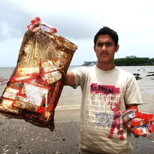 Man showing oil soaked biscuit packets due to container ship chitra colliding in sea Bombay Mumbai Man showing oil soaked biscuit packets due to container ship chitra colliding in sea Bombay Mumbai