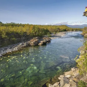 Man sitting on stone cliff over the river Abiskojakka