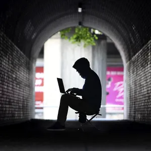 Man surfing on a laptop computer in a pedestrian tunnel Man surfing on a laptop computer in a pedestrian tunnel