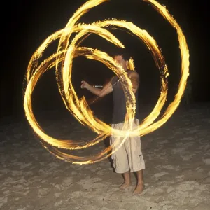 A man waves burning torches on the beach of Coral Beach Resort on the island of Ko Lanta A man waves burning torches on the beach of Coral Beach Resort on the island of Ko Lanta
