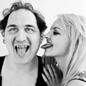 Man and woman sticking out their tongues Man and woman sticking out their tongues