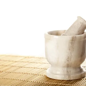 Marble mortar with pestle on bamboo mat Marble mortar with pestle on bamboo mat