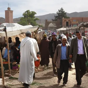 Market scene in Msemrir with people walking along the stalls