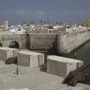 Massive fortress walls with cannons flanked by the sea