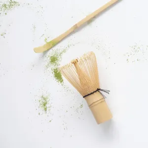 Matcha tea ceremony tools with scattered green powder on white background Matcha tea ceremony tools with scattered green powder on white background