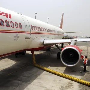 Mechanic checking engine and pumping fuel in aircraft at indira gandhi international airport