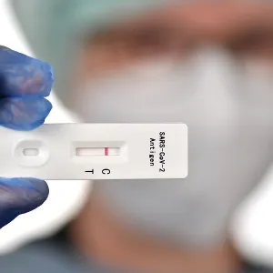Medical staff shows negative antigen rapid test