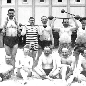 Men's group on the beach with weights