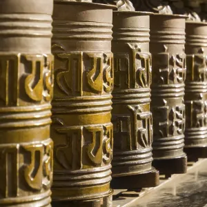 Metal prayer wheels in a row, artfully decorated Metal prayer wheels in a row, artfully decorated