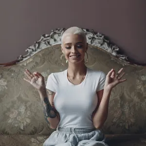 Millenial young woman with short blonde hair portrait sitting and meditate with ok sign mudra on vintage sofa Millenial young woman with short blonde hair portrait sitting and meditate with ok sign mudra on vintage sofa