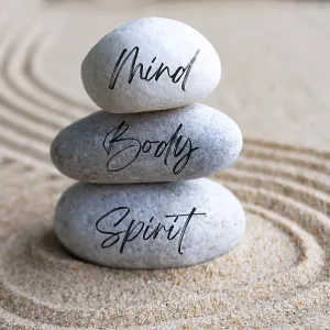 Mind, body and soul text on zen stones with bright light background