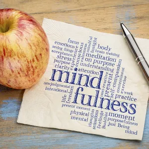 Mindfulness word cloud on a napkin with a fresh apple Mindfulness word cloud on a napkin with a fresh apple