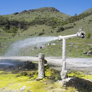 Mineral water spring with vertical pipeline in hilly landscape under blue sky Mineral water spring with vertical pipeline in hilly landscape under blue sky