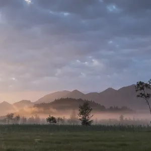 Scène du lever de soleil brouillé avec des montagnes lointaines.