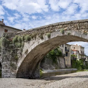 Puente de piedra medieval sobre un río.