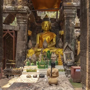 Modern Buddha statues in the central sanctuary of the mountain temple Wat Phu Modern Buddha statues in the central sanctuary of the mountain temple Wat Phu