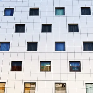 Modern building facade with a grid of square windows in various colors