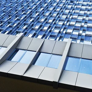 Modern building with a repetitive pattern of windows on a blue facade