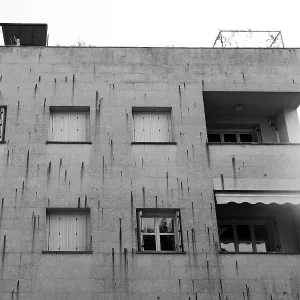 A modern concrete building with multiple windows and balconies